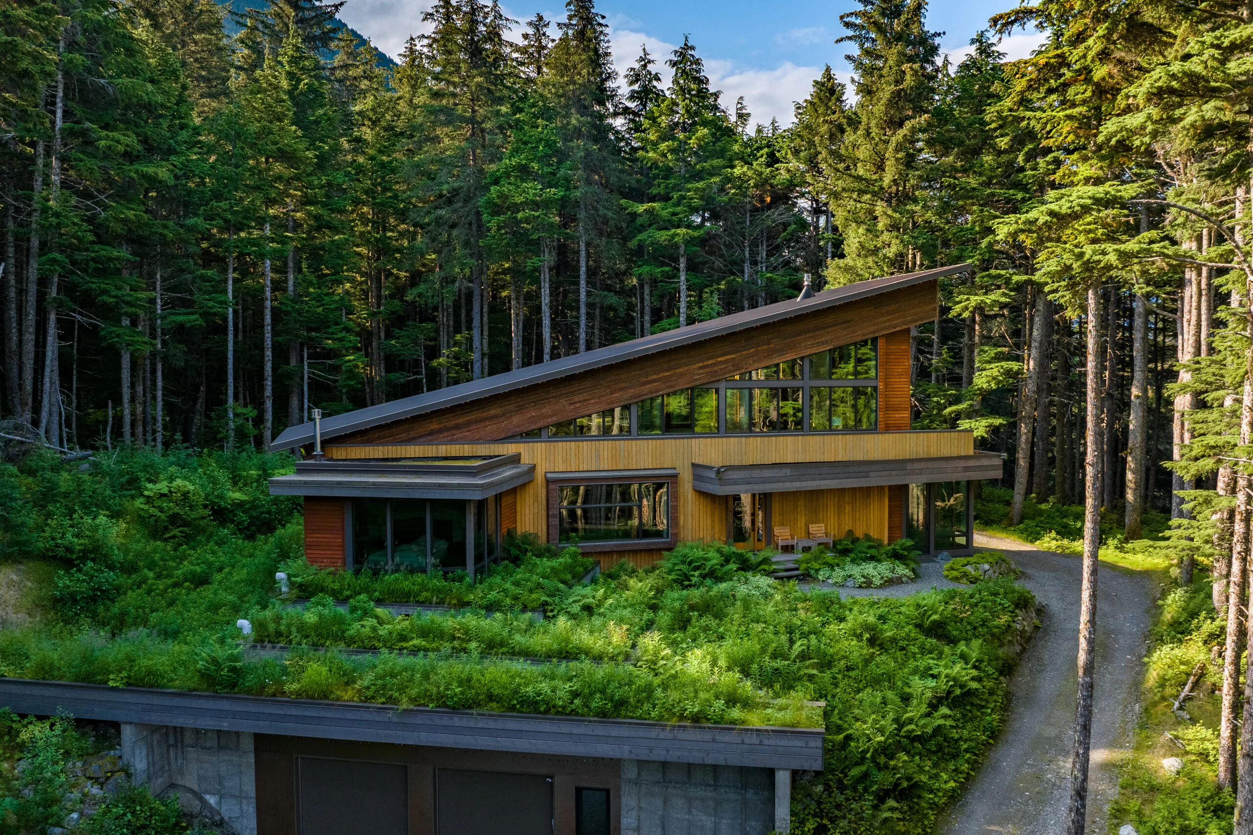 Aurora Ridge House — a cantilevered glass residence at blue hour above Hatcher Pass